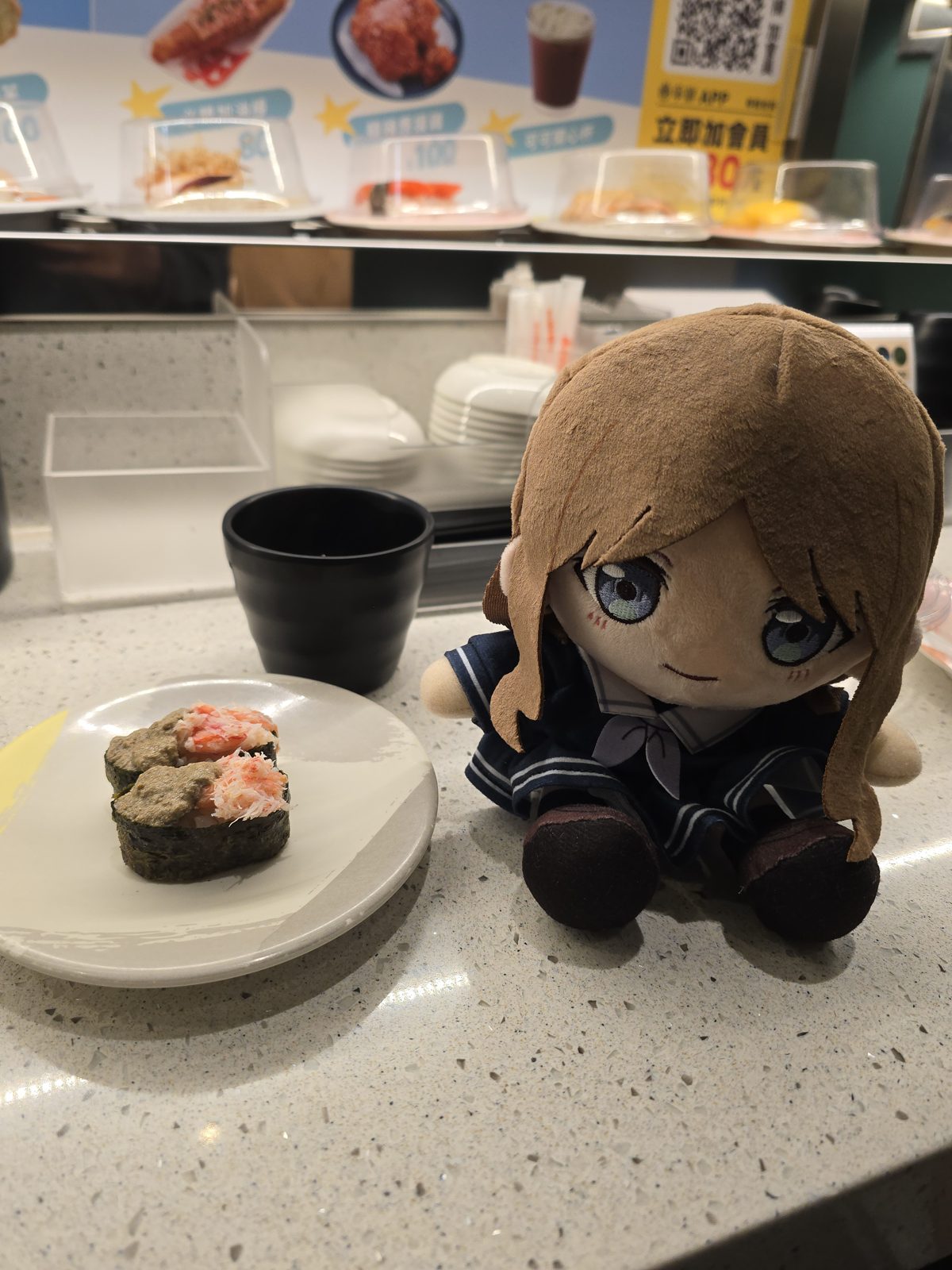 回転寿司のカウンターでぬいぐるみを撮った写真。寿司皿やメニューがあっても顔にピントを合わせる例