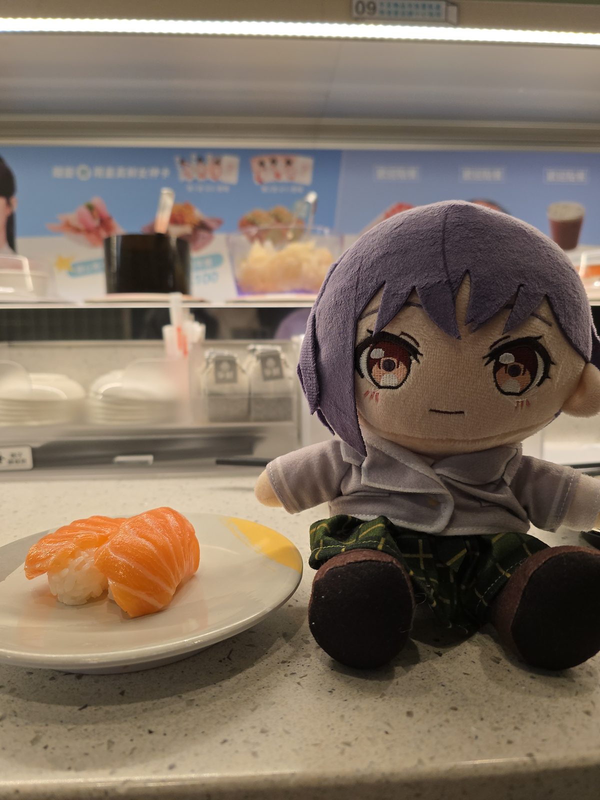 回転寿司のカウンターでぬいぐるみと寿司皿を撮った写真。飲食店でのぬい撮りスポット例